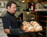 Lemoore Vineyard Restaurant manager Joe Jones shows off a pan full of lobster tails cooked to perfection and eagerly awaited by customers.
